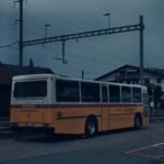 A yellow and white bus parked in a parking lot